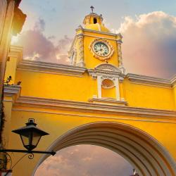 Arche de Santa Catalina jaune vif avec son horloge au coucher du soleil à Antigua Guatemala.