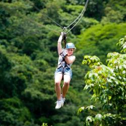 Jeune femme faisant de la tyrolienne au-dessus de la canopée de la forêt tropicale au Costa Rica.