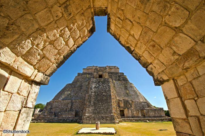 Pyramide du Devin cadrée à travers une arche maya sculptée sur le site d'Uxmal au Yucatan