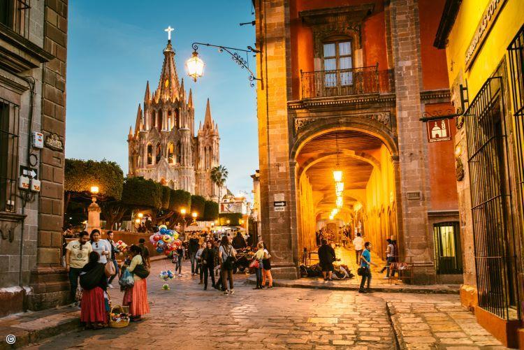 Rue pavee pittoresque de San Miguel de Allende avec vue sur l eglise eclairee en soiree