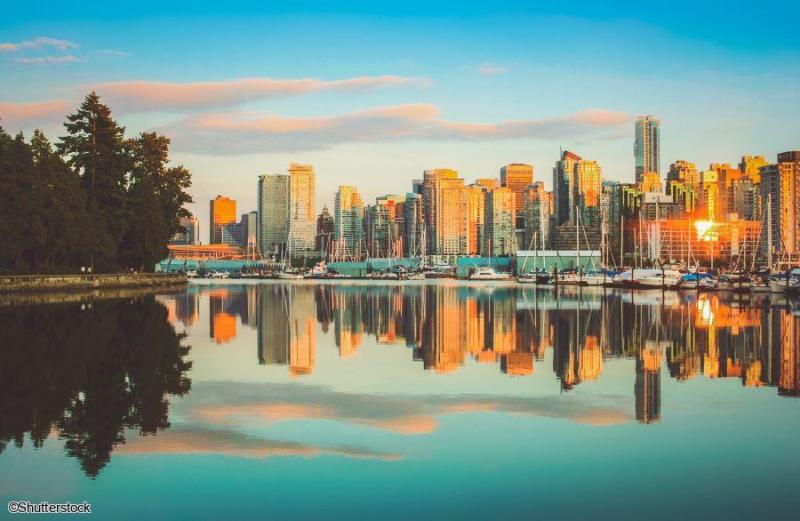 Circuit Joyaux de l'Ouest Canadien : Visite guidée de Vancouver Vue sur la skyline de Vancouver et ses gratte-ciels se reflétant dans l'eau lors d'un voyage dans l'Ouest canadien.