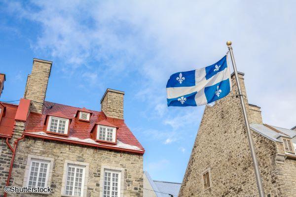 Le drapeau du Québec flottant fièrement devant une architecture historique dans la vieille ville lors d'un voyage au Canada