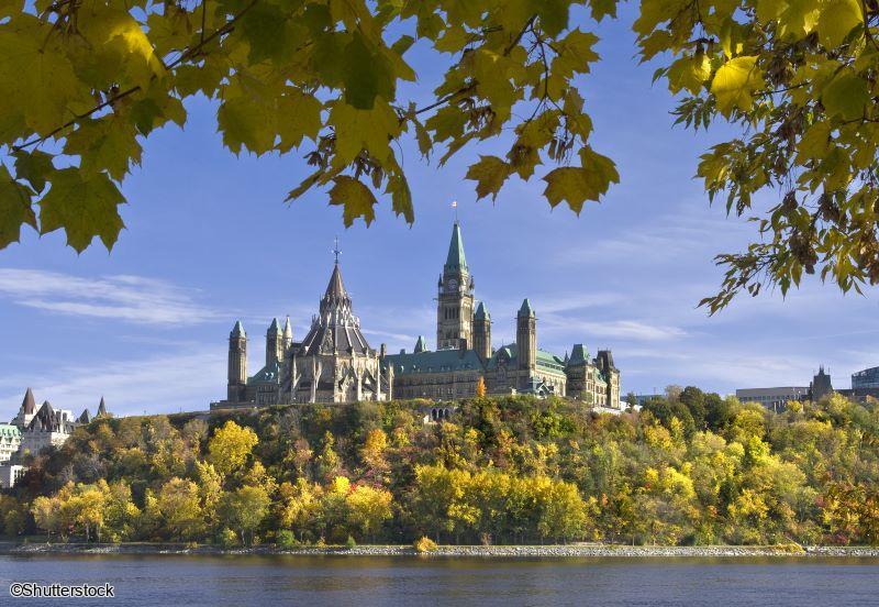 Vue des bâtiments du Parlement d'Ottawa encadrés par les arbres lors d'un voyage au Canada
