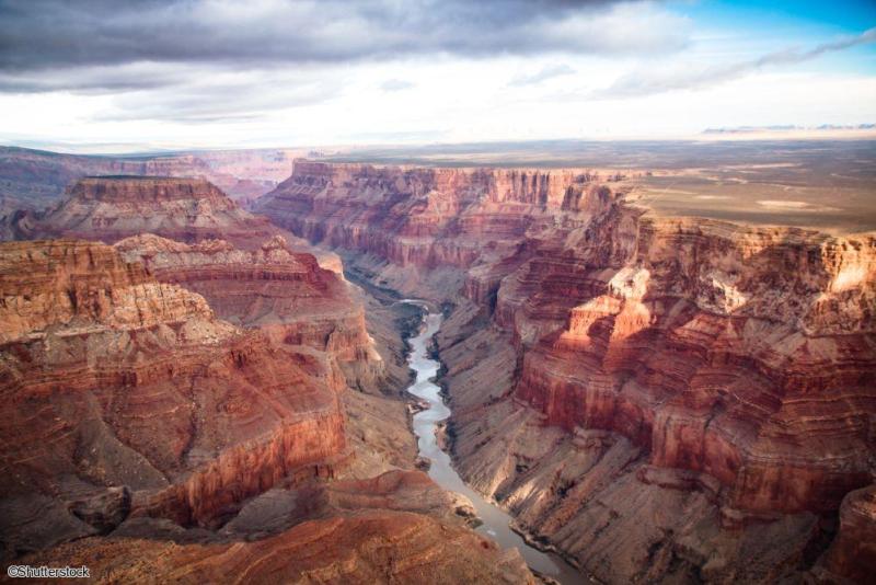 Circuit Ouest Américain en famille : contemplation des paysages grandioses du Grand Canyon Vue aérienne spectaculaire des gorges vertigineuses du Grand Canyon et du fleuve Colorado serpentant au fond lors d'un voyage en famille aux États-Unis.