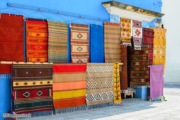 Tapis et textiles artisanaux colorés suspendus devant une échoppe à Oaxaca au Mexique